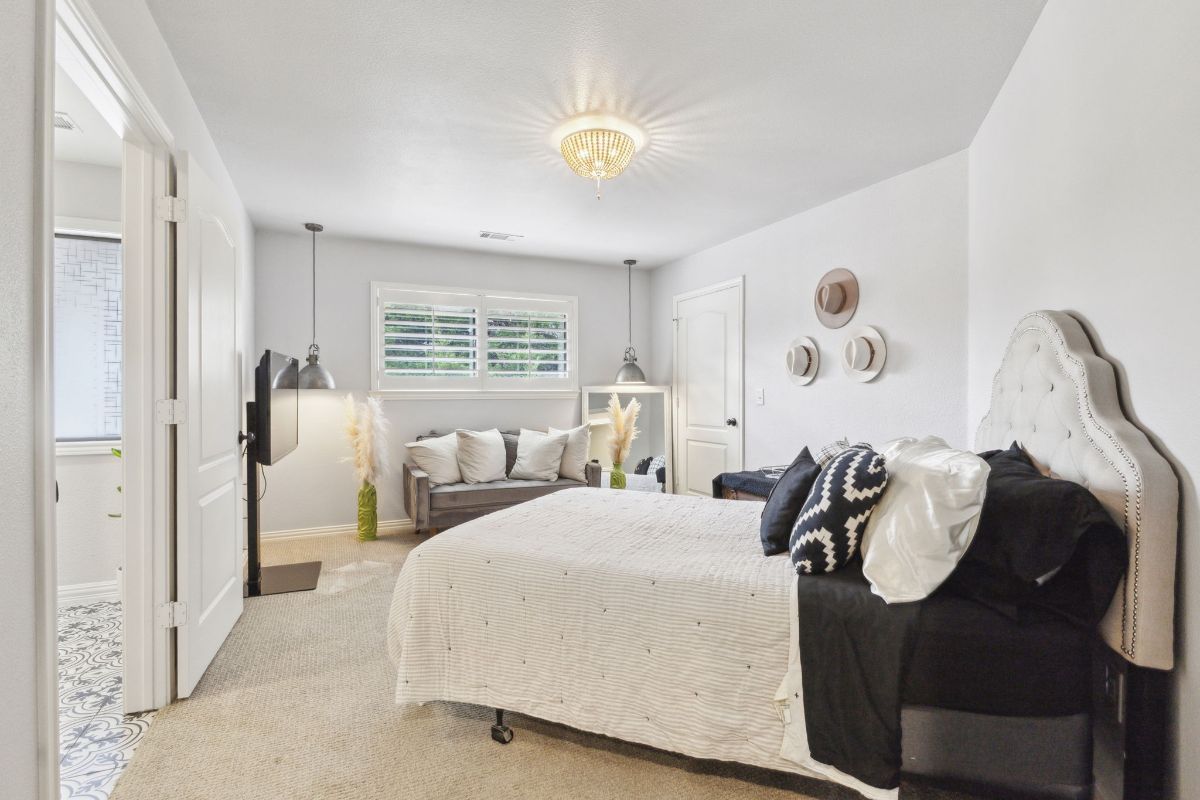 Bed is positioned against a white wall with black and white bedding.