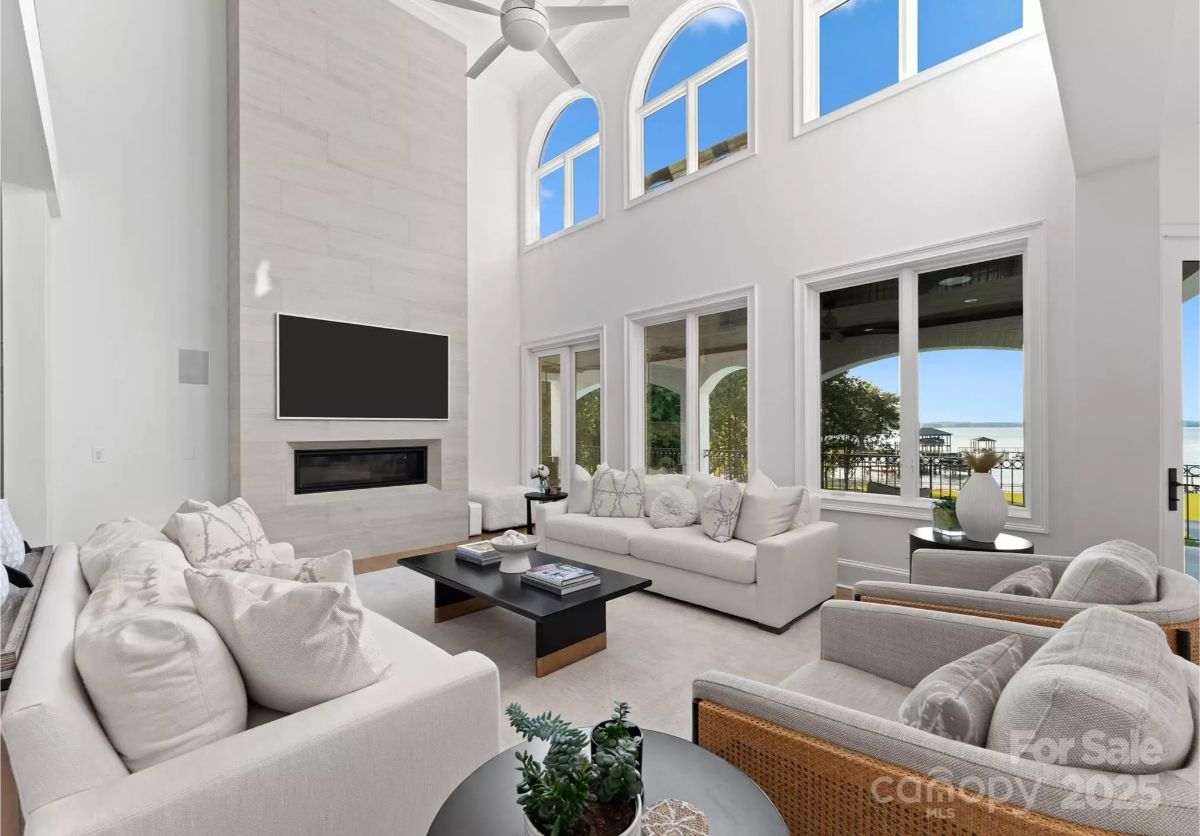 Tall windows provide expansive lake views from the two-story living room.