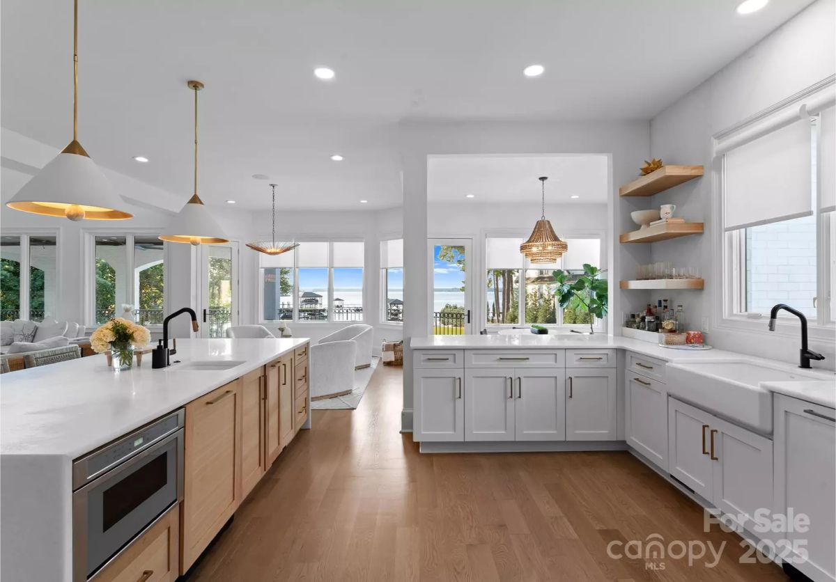 White cabinetry and countertops contrast with light wood flooring and island base.