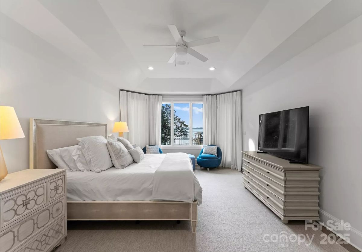 Tray ceiling and recessed lighting define the bedroom’s architectural details.