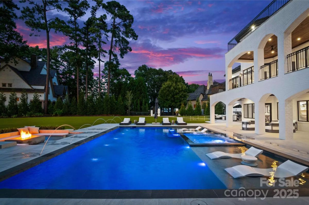 Rectangular pool includes built-in loungers and a hot tub section.