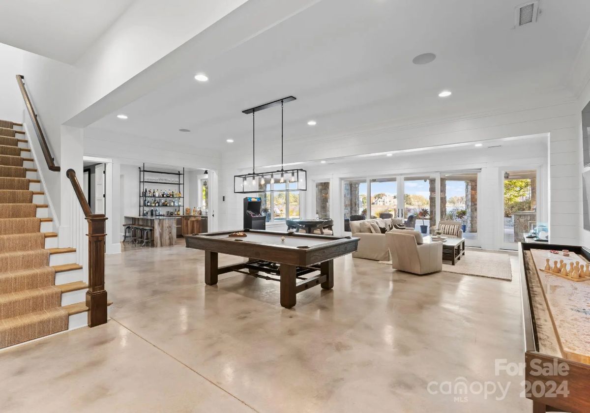 Basement game room includes pool and shuffleboard tables, plus seating with lake views. 