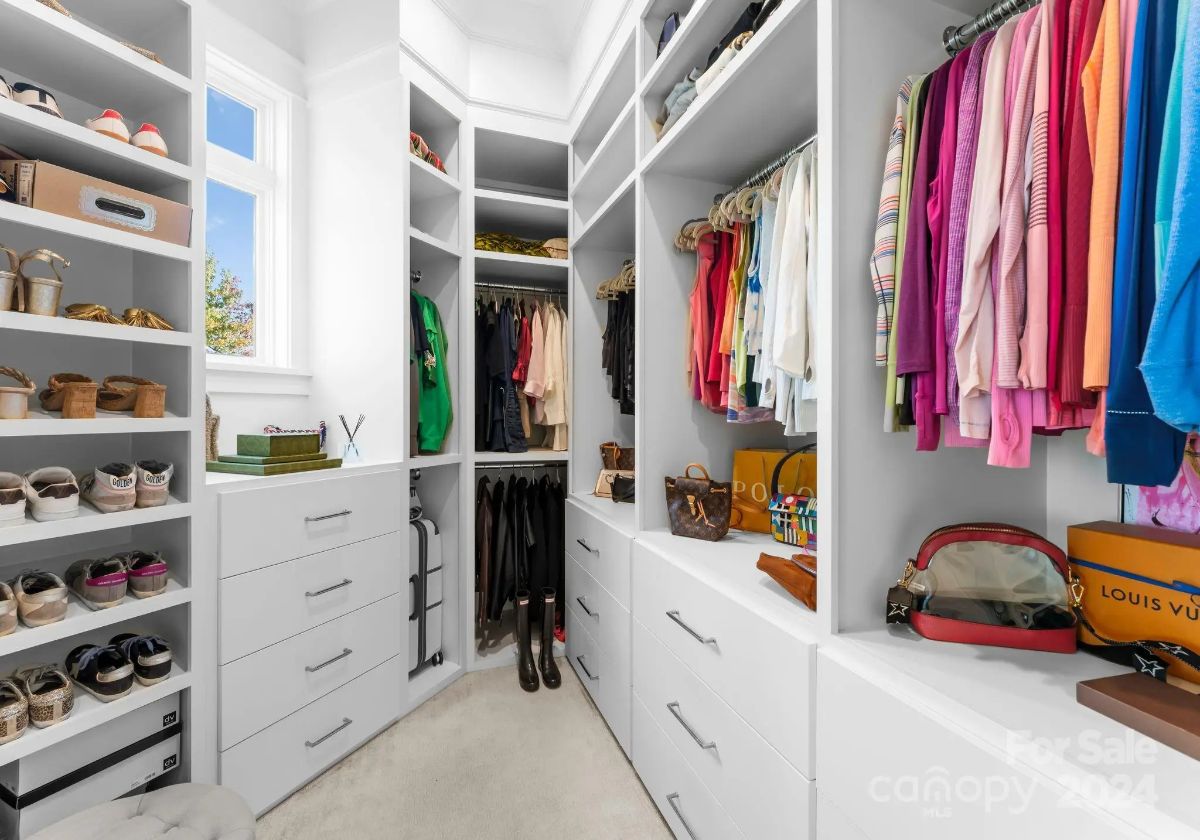 Walk-in closet is well-organized with drawers, shelves, and hanging space for clothing and accessories. 