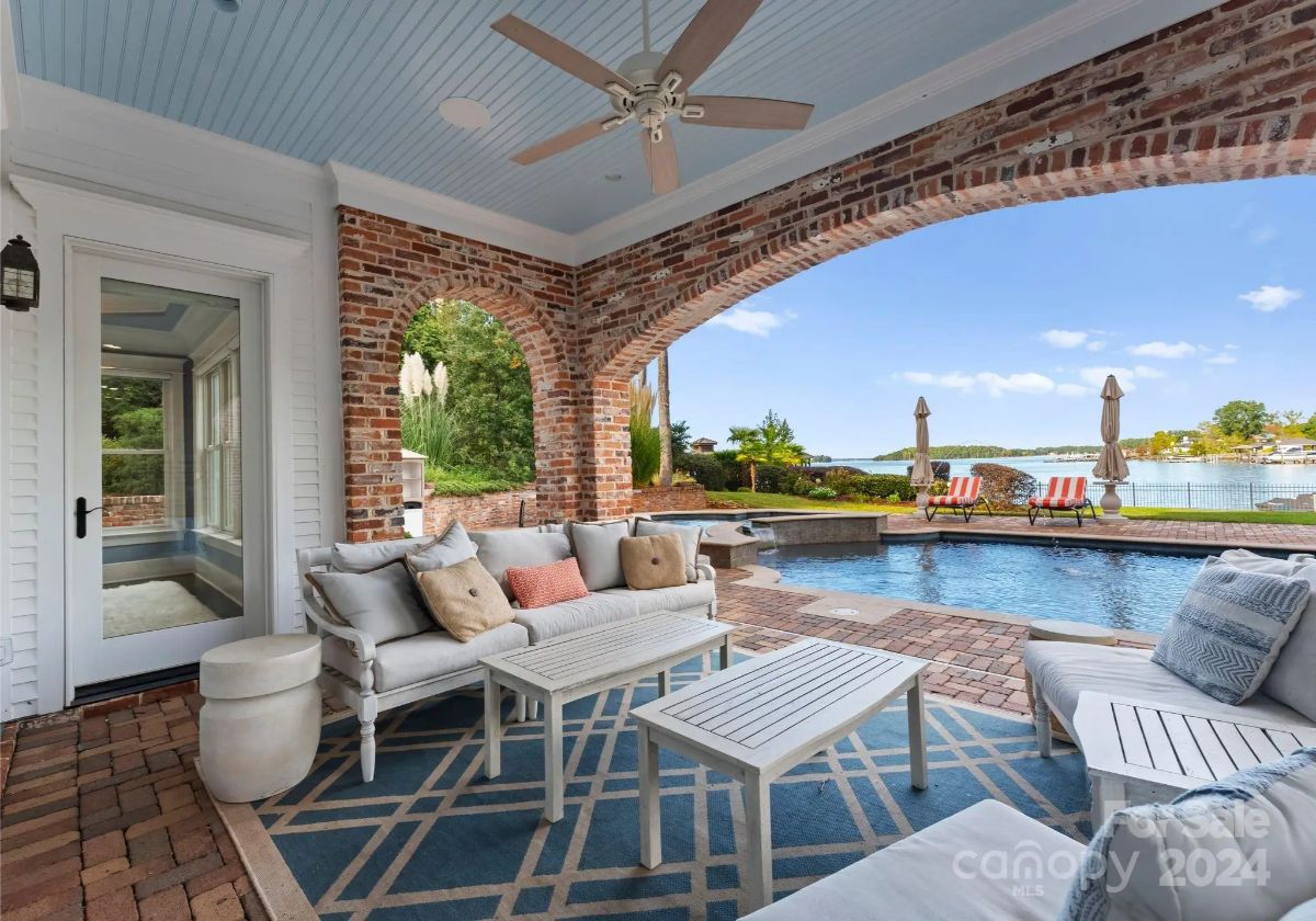 Arched brick openings frame the pool and lake beyond.