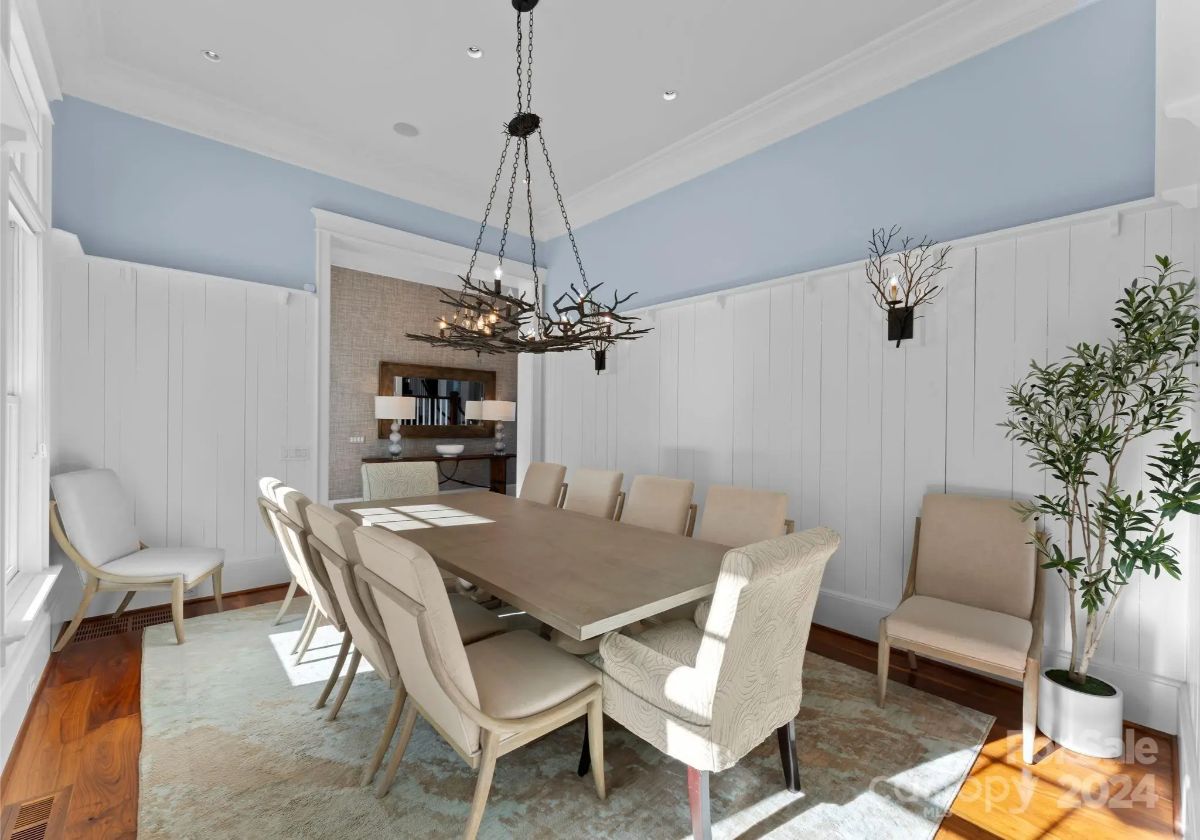 Sophisticated dining room with unique chandelier and white wainscoting. 
