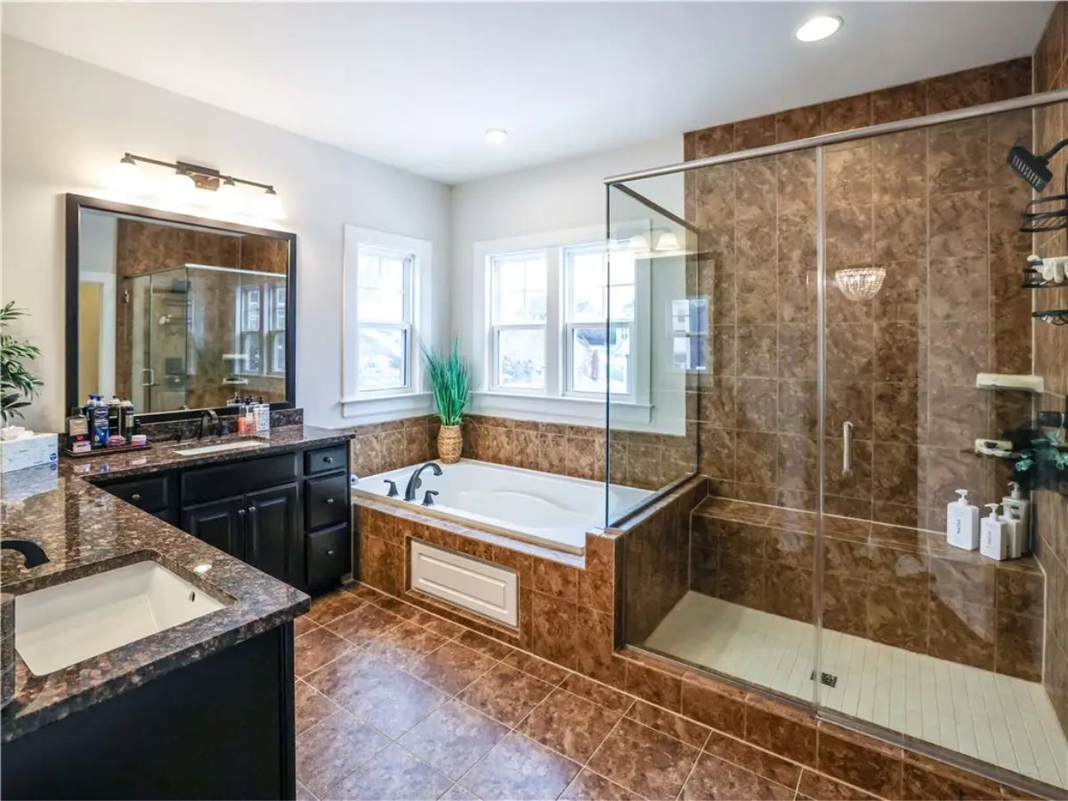 Bathroom with a glass-enclosed shower and built-in bathtub.