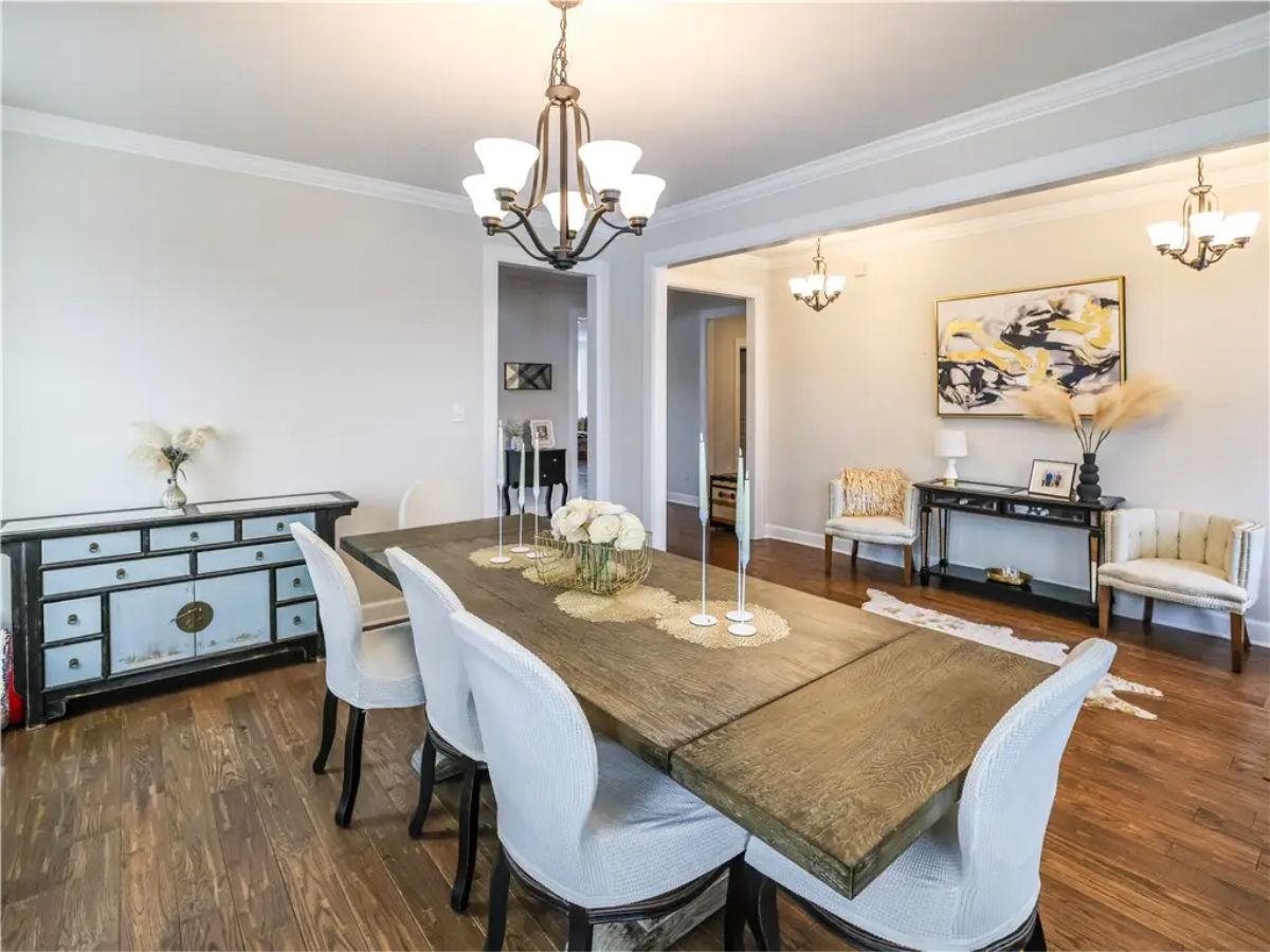Dining room with a long wooden table and upholstered chairs.
