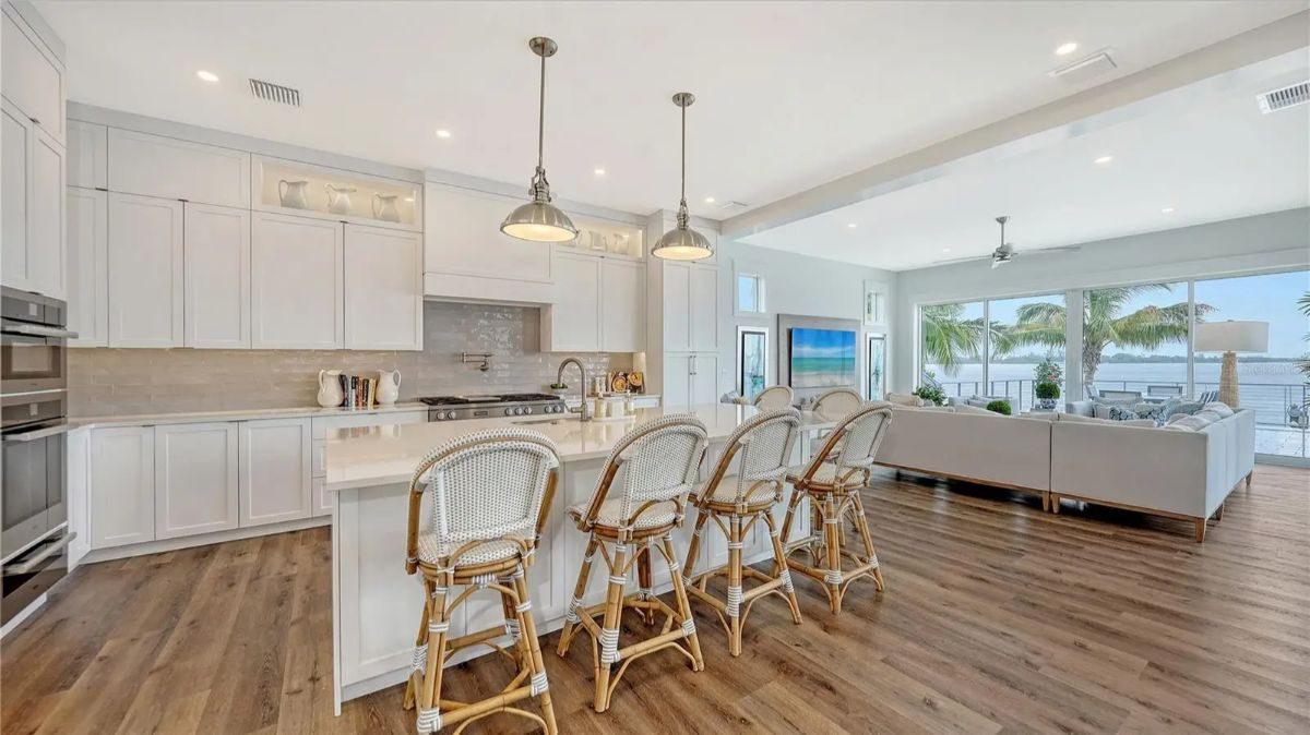 Kitchen with white cabinetry, stone countertops, and stainless steel appliances.