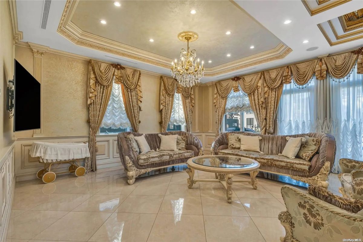 Sofas with carved wood trim and patterned upholstery are arranged around a glass coffee table.