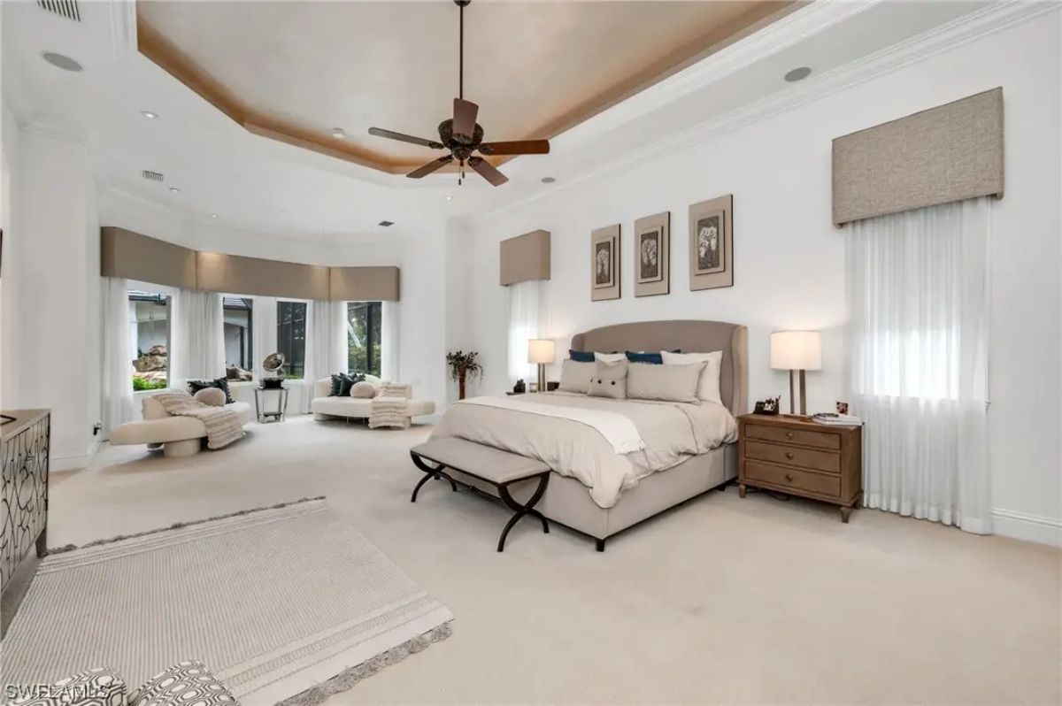 King-sized bed is centered between two wood nightstands and matching lamps.