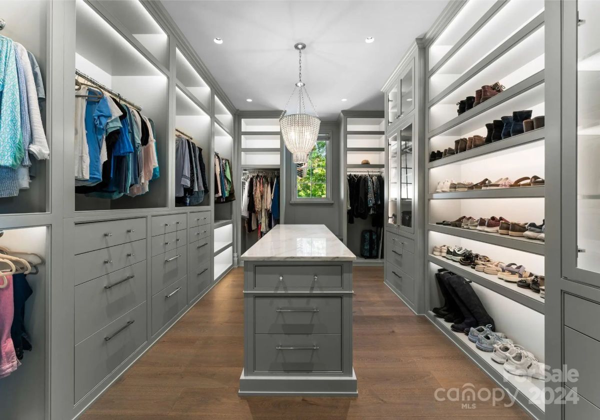 Soft lighting glows against sleek cabinetry in a walk-in closet designed for effortless elegance. 