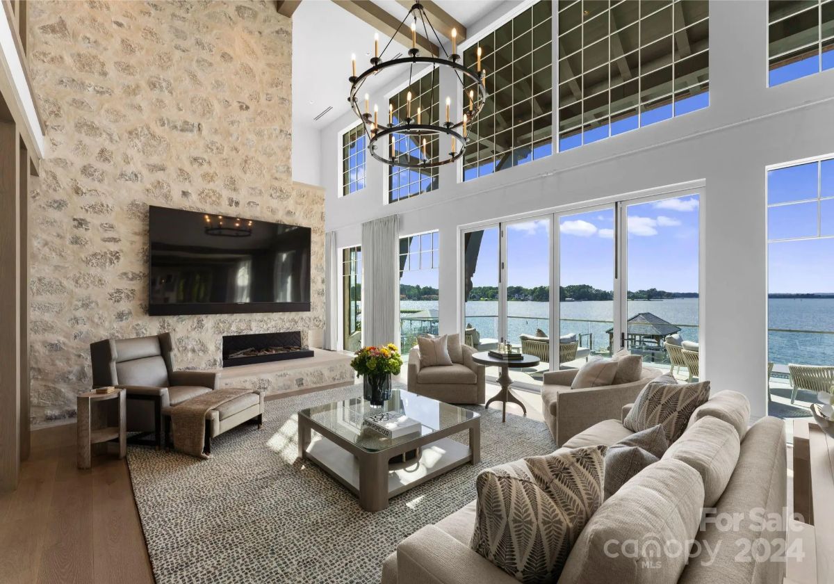 Rustic stone walls and a dramatic chandelier set the stage for a luxurious yet cozy great room. 