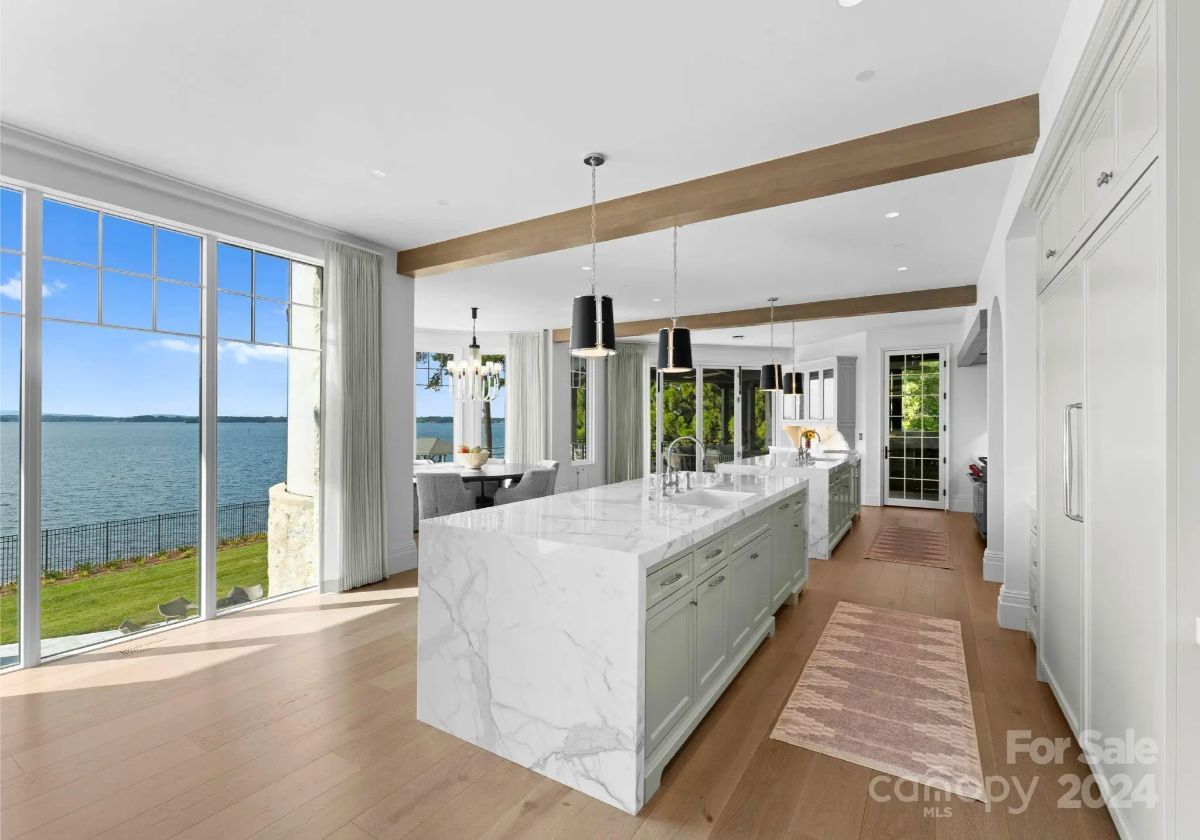Light streams through glass walls, illuminating a kitchen where nature and design intertwine. 