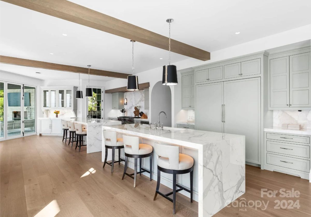 Waterfall marble counters and sleek cabinetry transform this kitchen into a culinary dream. 