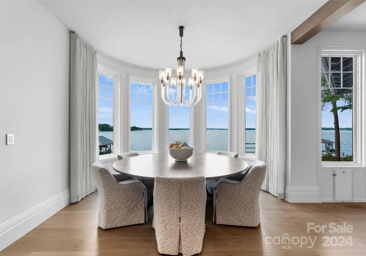 Floor-to-ceiling bay windows wrap around a dining space made for intimate lakefront meals. 