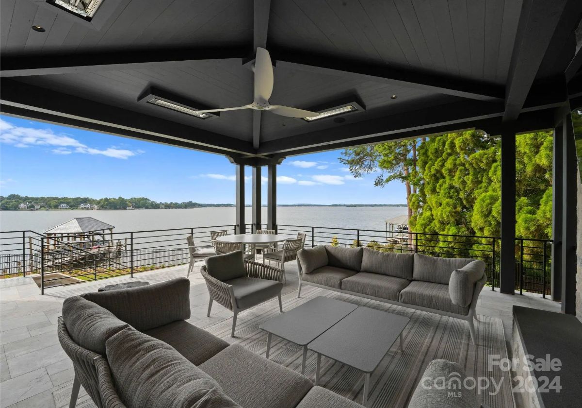 Plush outdoor seating under a covered terrace turns lake views into the ultimate relaxation spot. 