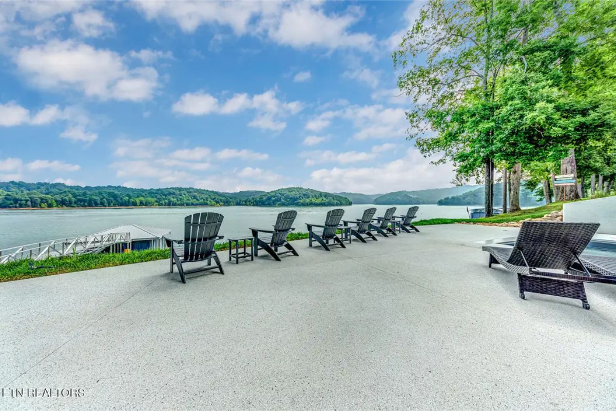 Serene lakeside lounging area with Adirondack chairs positioned to take in the breathtaking waterfront views. 