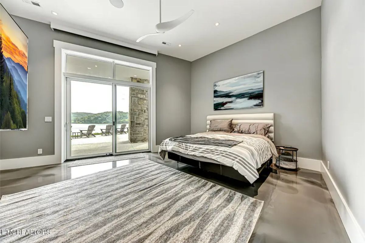 Tranquil bedroom with sleek decor, a soft neutral color scheme, and sliding doors leading to a private patio. 