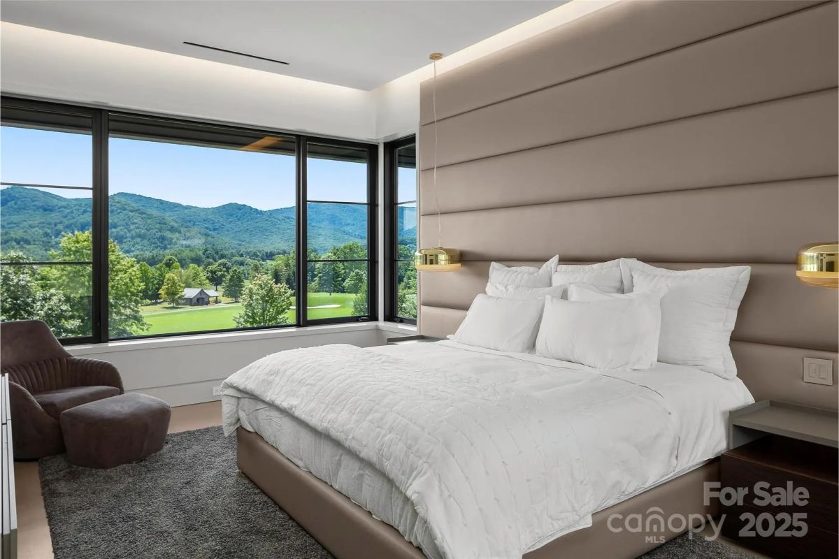 An oversized headboard and floor-to-ceiling windows bring a luxurious hotel-like touch to this bedroom retreat. 
