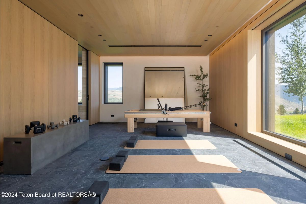 Serene yoga or meditation room with floor mats, light wood finishes, and peaceful window views. 