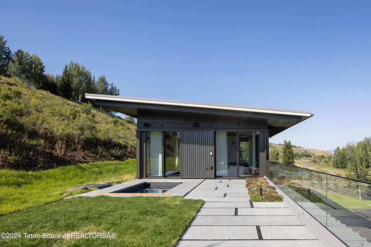 Detached modern guest house or studio with clean lines, a hot tub, and hillside views. 