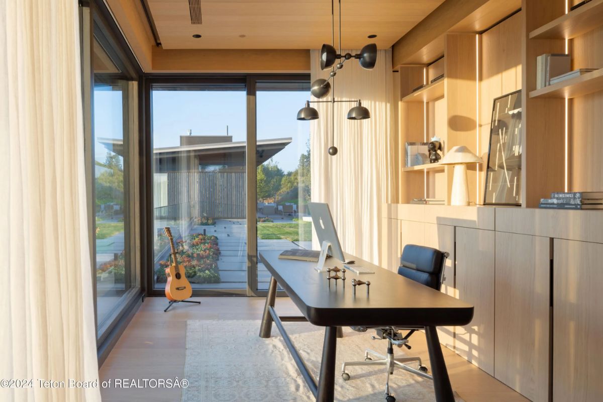 Serene home office with custom built-ins, a clean-lined desk, and floor-to-ceiling glass for natural inspiration. 