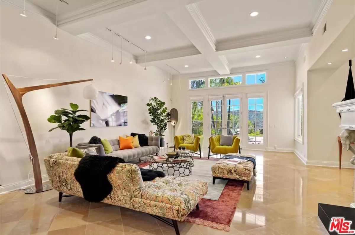 Living area features patterned sofas and accent chairs around a modern coffee table.