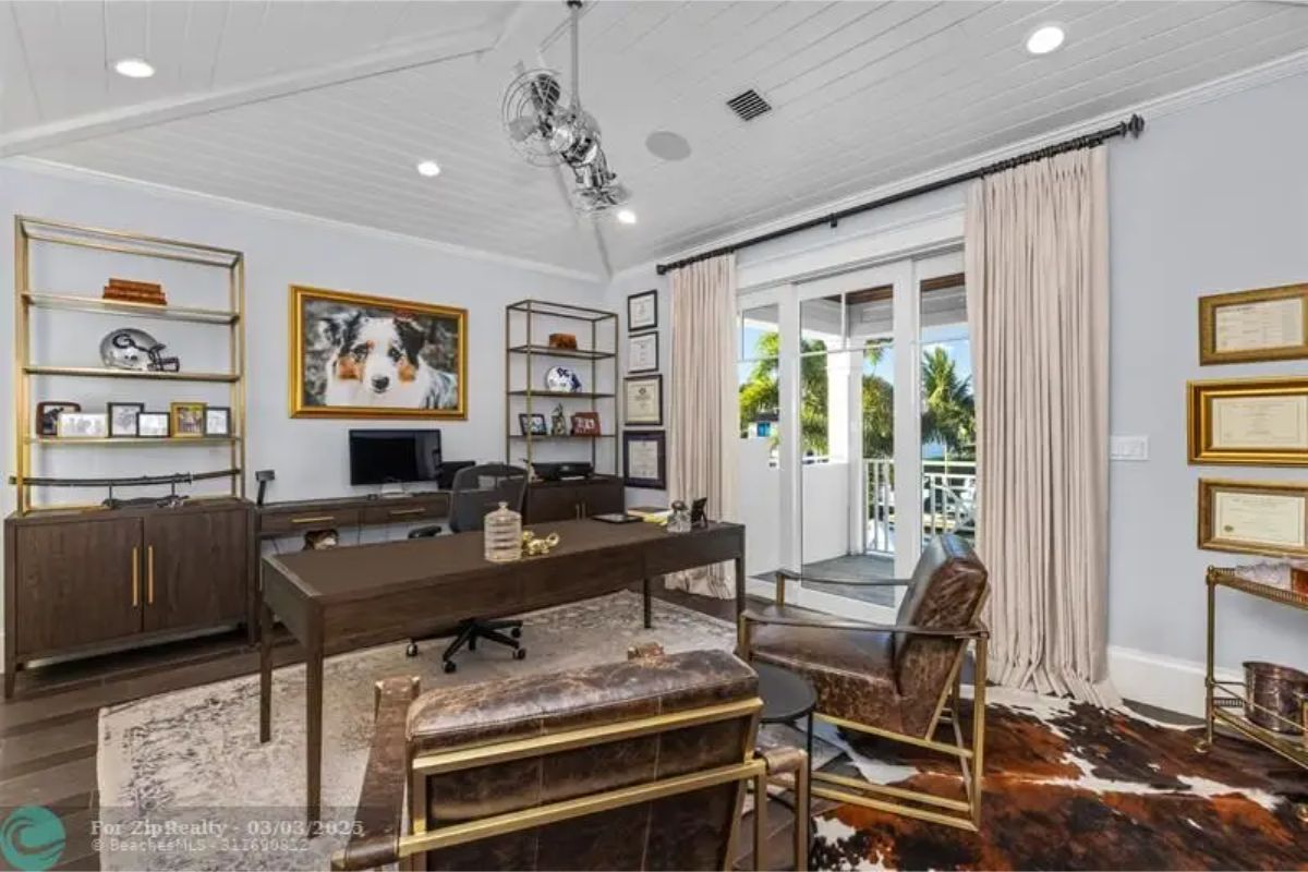 Office space has a large desk, leather chairs, and bookshelves on both sides.