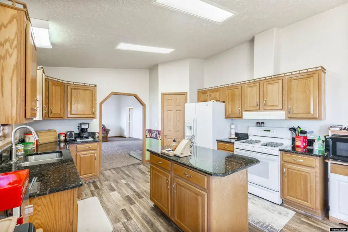 Wood cabinetry lines the walls with dark granite countertops.