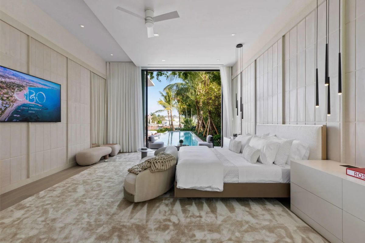 Resort-style bedroom opens to a pool view, blending luxury with tropical tranquility. 