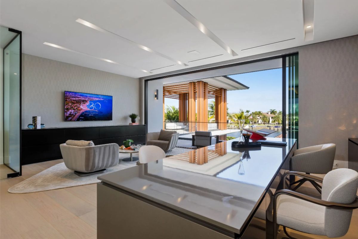 Open-concept lounge with modern office setup and seamless indoor-outdoor flow. 