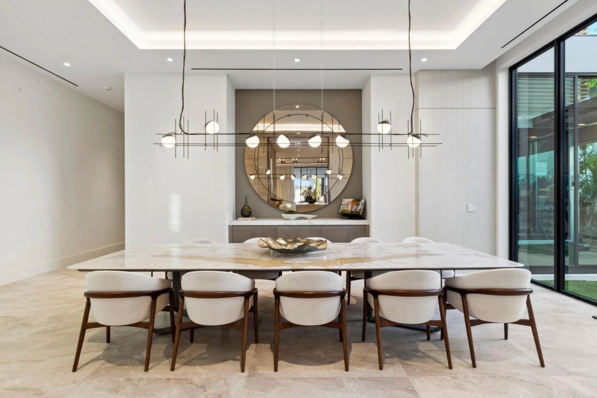 Another angle of the dining room highlights a large circular mirror and minimalist elegance. 