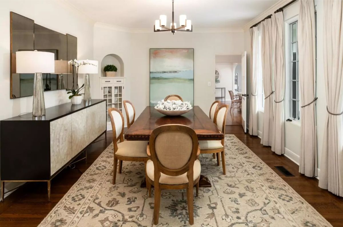 Long wood table is surrounded by eight oval-back upholstered chairs
