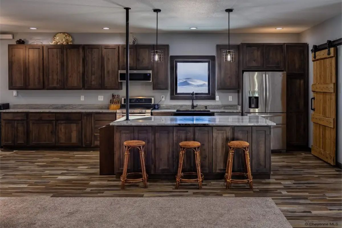 Dark wood cabinetry contrasts with light stone countertops.