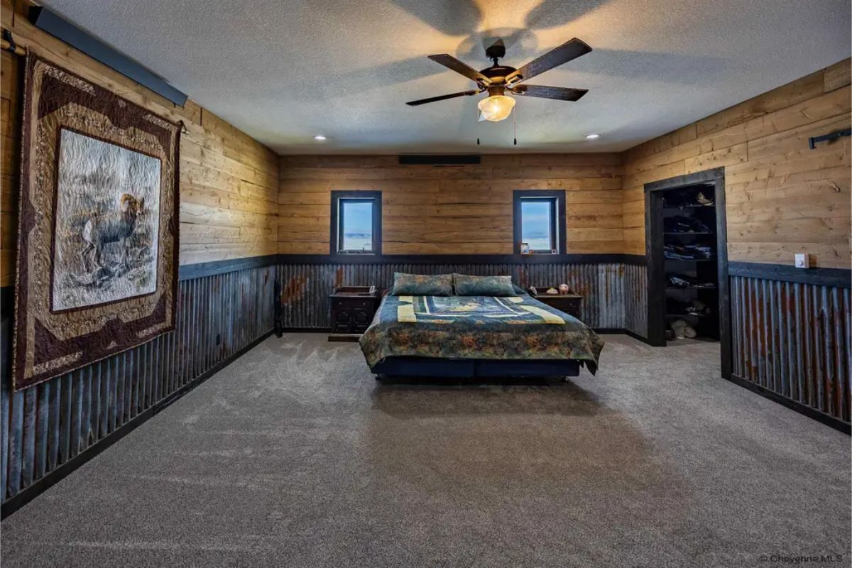 Wood-paneled walls with dark wainscoting surround a spacious sleeping area.