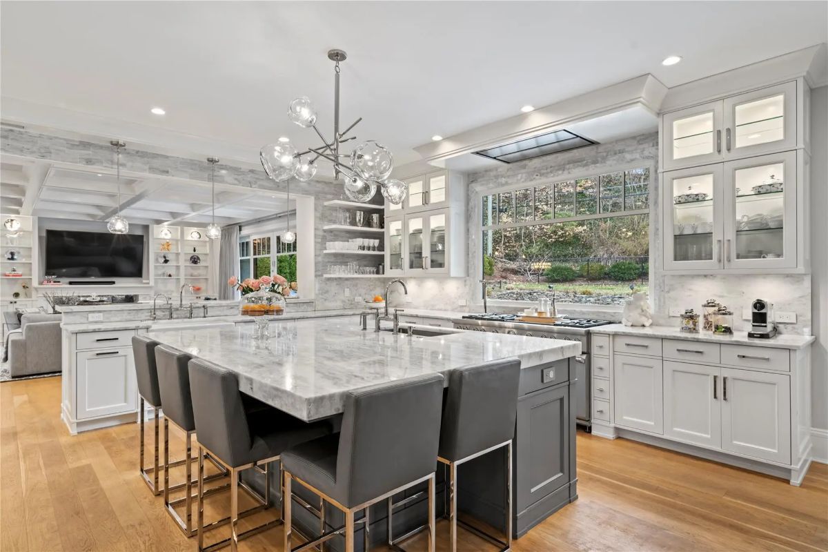 Marble countertops and a large island with seating for six define the space.