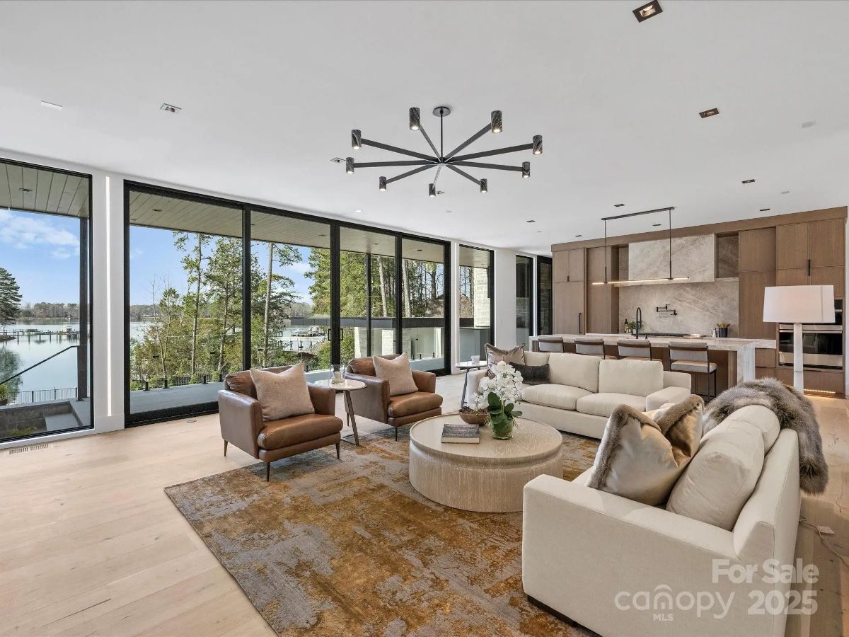 Open-concept living space with large sliding glass doors overlooking a lake.
