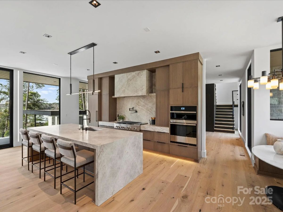 Light wood cabinetry contrasts with a stone backsplash and neutral countertops.