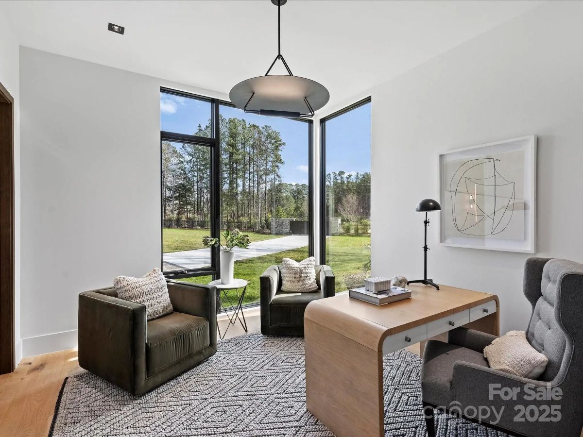 Compact office setup positioned in a bright corner space with floor-to-ceiling windows.