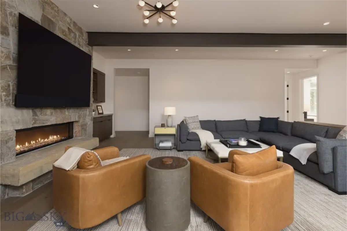 Stylish lounge area features a mix of leather and fabric seating arranged around a modern linear fireplace.