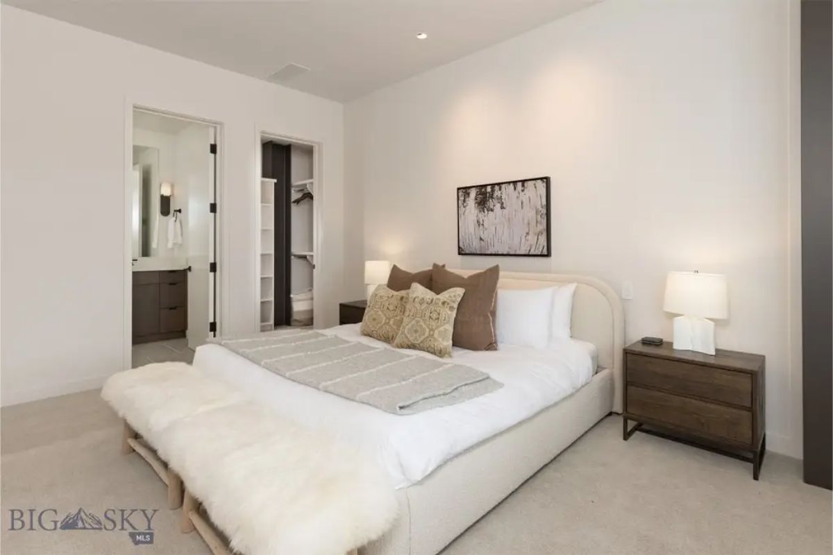 Cozy bedroom with soft lighting, neutral tones, and plush bedding for a warm ambiance.