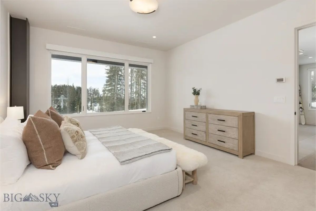 Spacious bedroom featuring large windows that provide a bright and airy atmosphere. 