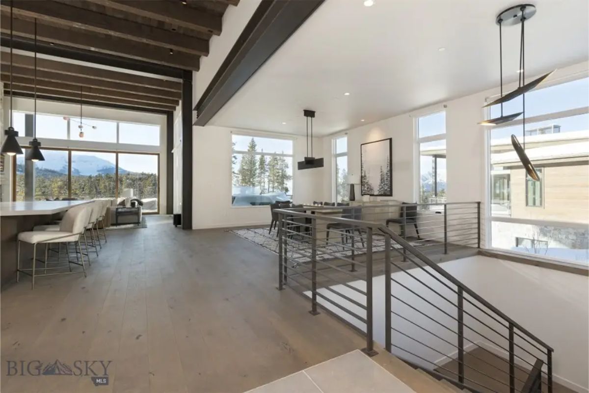 Open-concept living and dining area with floor-to-ceiling windows offering panoramic mountain views.