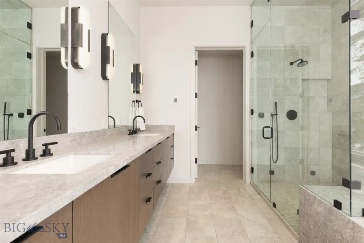 Luxurious bathroom with a double vanity, sleek black fixtures, and a glass-enclosed shower.