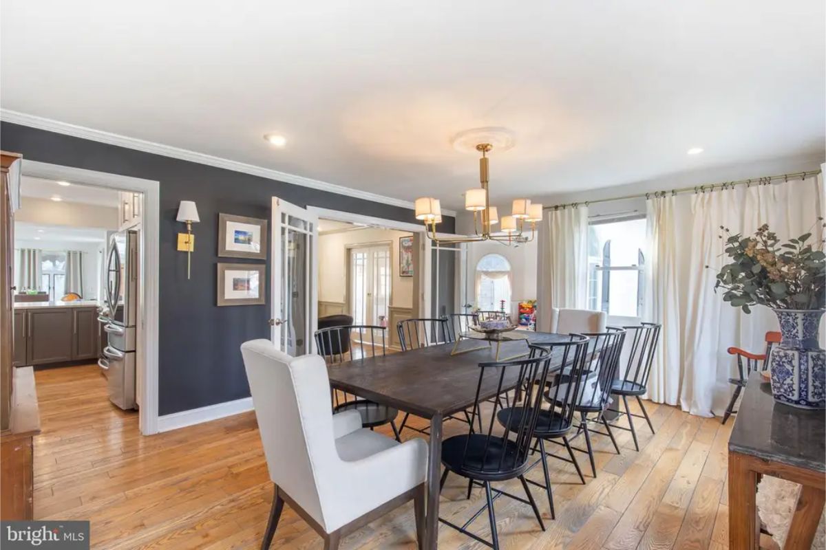 Open dining area with a long wooden table and black chairs.