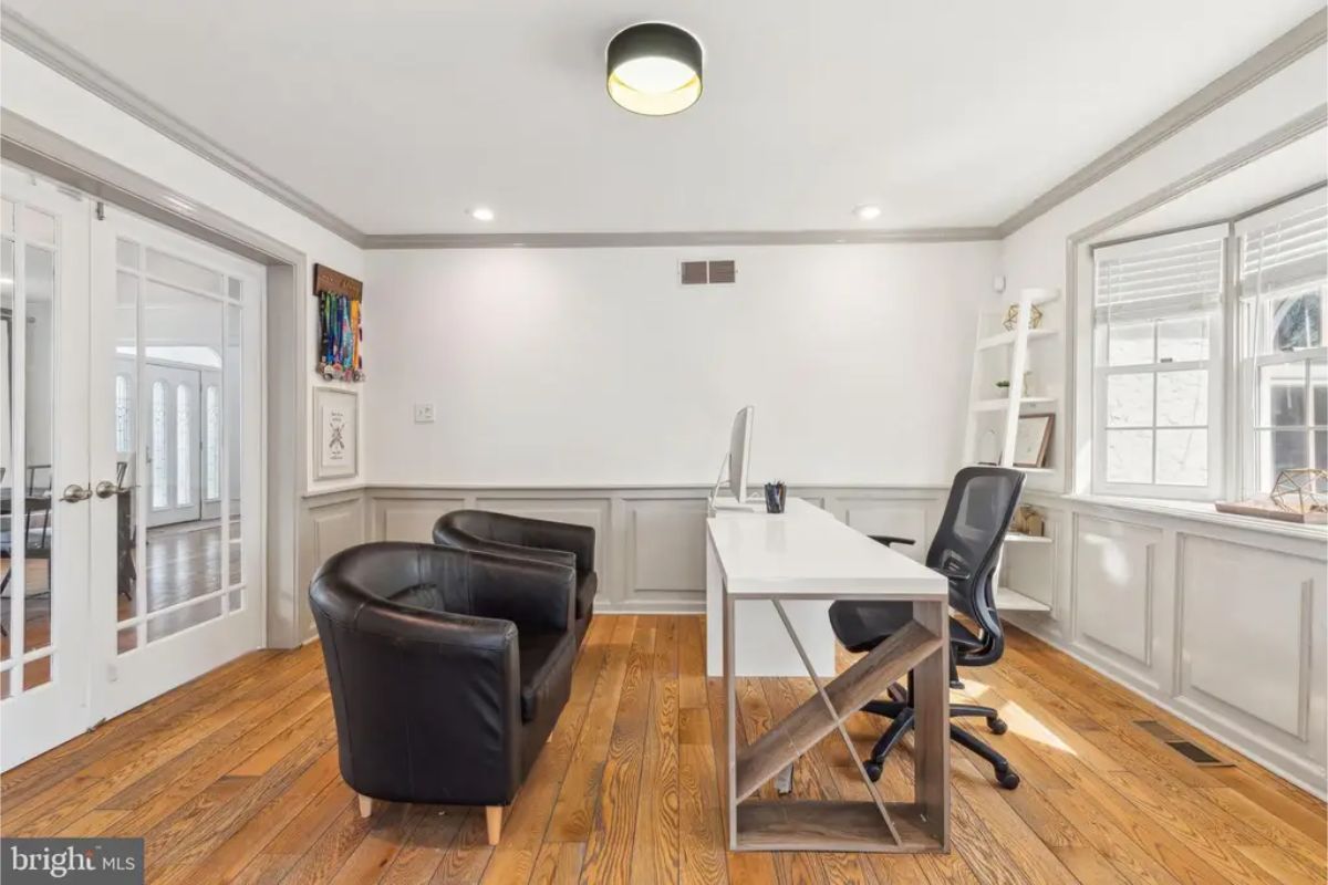 Office space with white wainscoting and neutral walls.