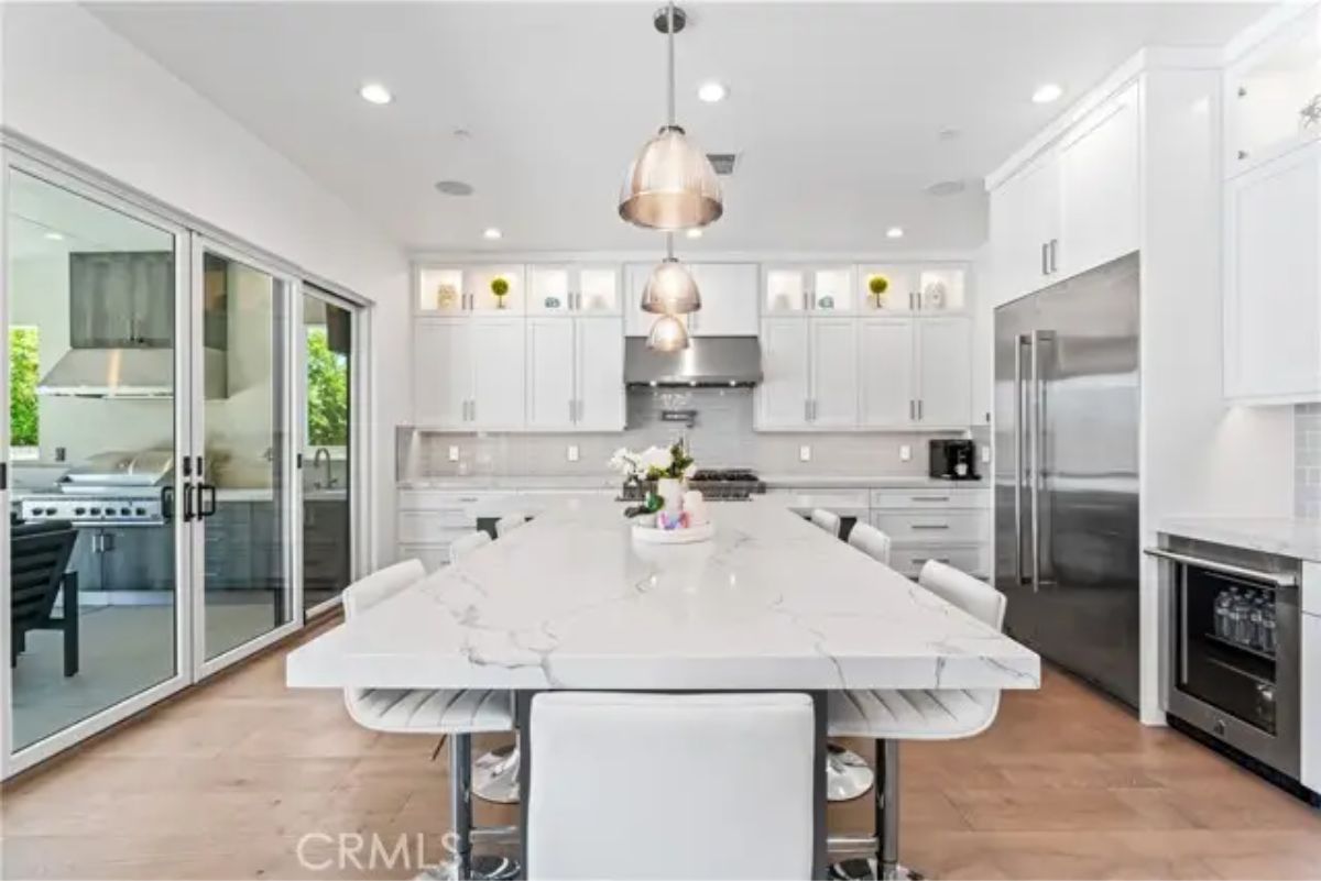 Kitchen features a large marble island with seating for five.