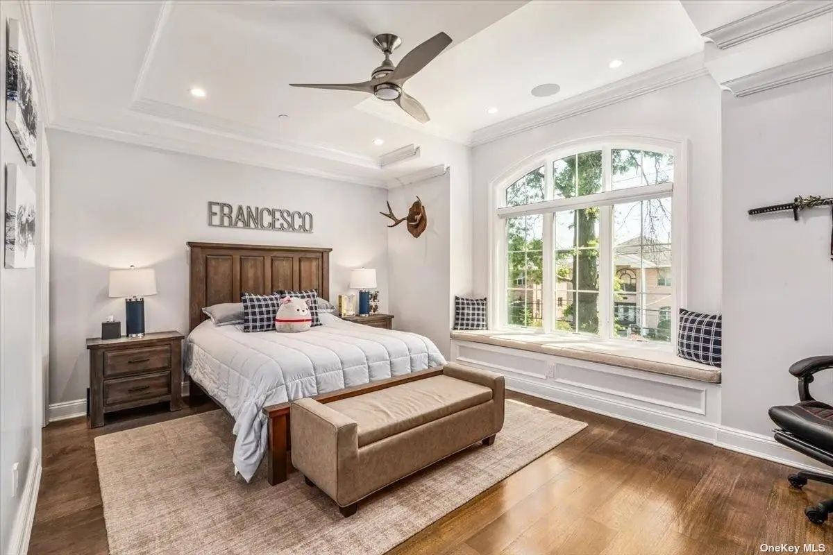 King bed with wood frame is flanked by matching nightstands and lamps.