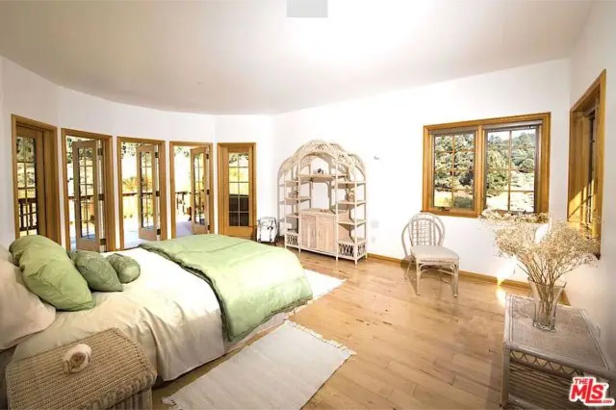 Glass-paneled double doors form a curved wall on one side of the room.