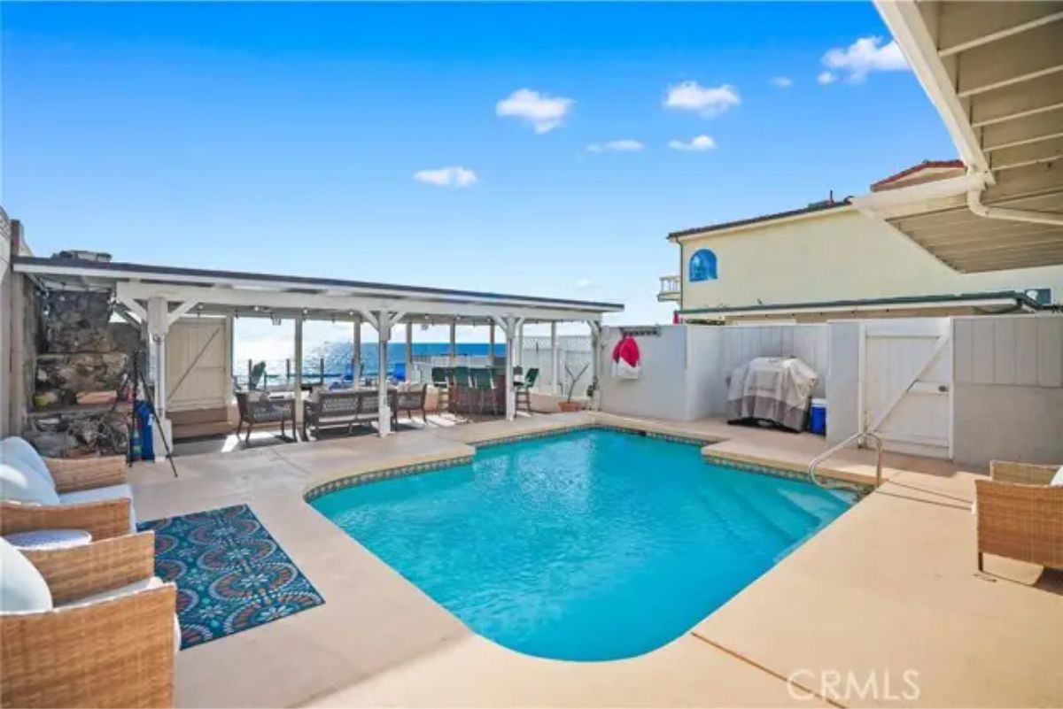 Enclosed backyard with rectangular in-ground pool.